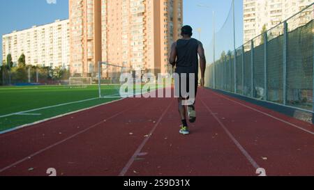 Niedrige Startposition Rückansicht Läufer afroamerikanischer Mann Guy Sportsman Vorbereitung Vorbereitung Start auf Laufstrecke männlicher Läufer Jogger Laufmarathon Stockfoto