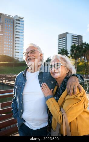 Älteres Paar geht Arm in Arm, lächelt bei Sonnenuntergang in einem Park, genießt romantische und friedliche Momente Stockfoto