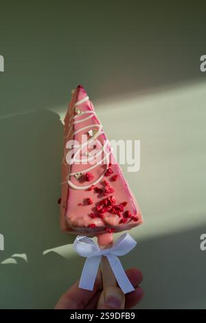 Neuer Look des trendigen Mini-Eis-Käsekuchens auf Stock in leuchtend rosa Farbe auf pastellfarbenem Hintergrund. Kopierraum Mustervorlage für Bäckerei Mini Dessert Coffee Shop. Kuchen zum Mitnehmen Süße Weihnachtsgeschenk-Idee eine Person Stockfoto