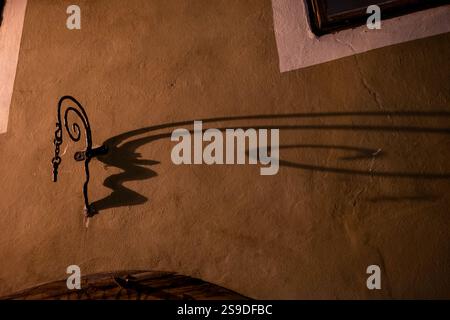 Schlüssel und Schatten auf rustikaler Wand bei Nacht Stockfoto