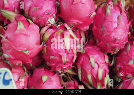 Eine herrlich frische Drachenfrucht, die in einem traditionellen Korb auf einem lebhaften Markt präsentiert wird Stockfoto