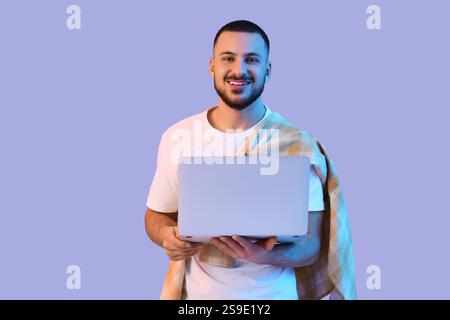 Junger Mann mit Laptop auf hellem Hintergrund Stockfoto