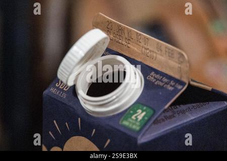 In dieser Abbildung ist ein Milchkarton mit Arla und seine gefesselte Kappe zu sehen. Ein EU-weites Mandat, das 2024 umgesetzt wurde, zielt darauf ab, Kunststoffabfälle zu reduzieren, indem sichergestellt wird, dass die neuen „Haltekappen“ an Flaschen befestigt bleiben, wodurch die Wahrscheinlichkeit erhöht wird, dass sie zusammen recycelt werden. Quelle: SOPA Images Limited/Alamy Live News Stockfoto