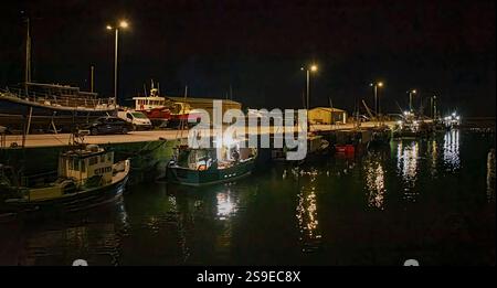 Burghead Harbour Moray Scotland vertäute Fischerboote bei Nachtfischern, die an der Sortierung des Fangs arbeiteten Stockfoto