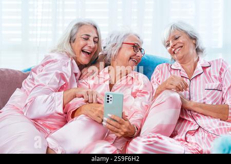 Schöne ältere Frauen, die zu Hause eine lustige Pyjama-Party haben - Gruppe von fröhlichen älteren weiblichen Freunden, die zu Hause Spaß haben, Konzepte über alte Leute, LIFE Stockfoto