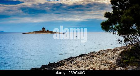 Pokonji Dol Island & Leuchtturm mit kleinem Boot, Pokonji Beach, Hvar, Kroatien Stockfoto