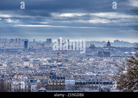 Panoramablick auf die Pariser Stadtlandschaft mit bewölktem Himmel mit ikonischen Gebäuden, dichten Dächern und einer modernen Skyline im Dezember. Stockfoto