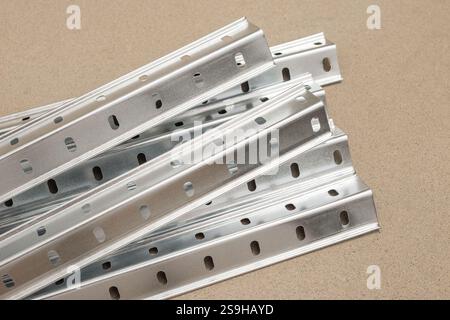 Ecken mit perforiertem Metallprofil für verstellbare Regaleinheit auf beigefarbenem Hintergrund Stockfoto
