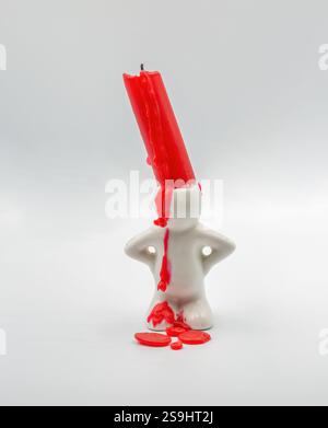 Roter Kerzenstich in niedlicher Kerzenleuchter in Form eines Mannes Nahaufnahme auf weißem Hintergrund Stockfoto