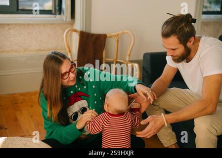 Genießen Sie einen herzerwärmenden Familienspaß mit dem liebenswerten Baby in einer gemütlichen Innenumgebung Stockfoto