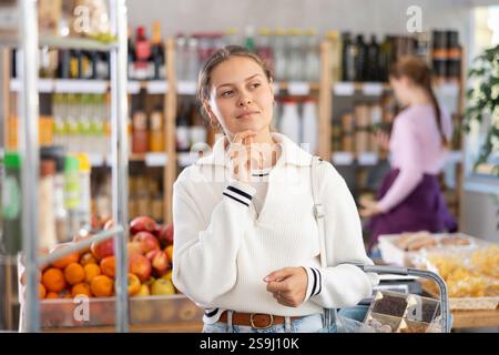Junge Frau im Supermarkt Stockfoto