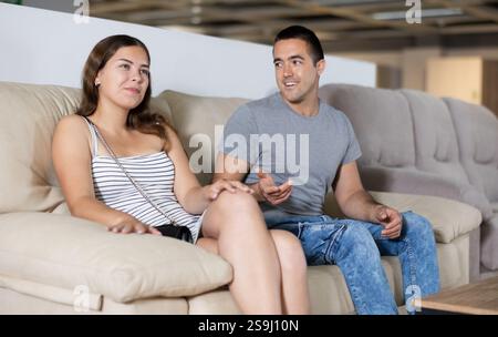 Mann und Frau wählen das Sofa im Möbelgeschäft Stockfoto