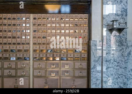 Eine antike Postwaage befindet sich an der Wand neben den Briefkästen im Postamt in Anaconda, Montana, USA Stockfoto