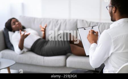 Psychotherapeut, der depressive afroamerikanische Patientin konsultiert und eine Therapiestunde in der Klinik hat Stockfoto