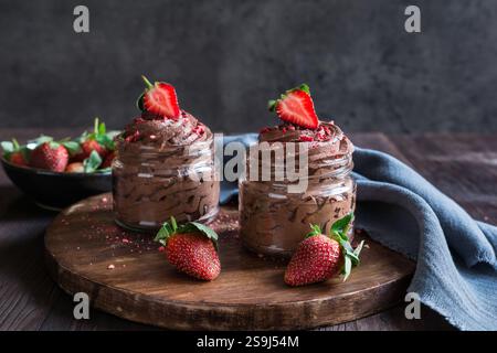 Köstliches Schokoladenmousse mit frischen und gefriergetrockneten Erdbeeren in Glasgläsern Stockfoto
