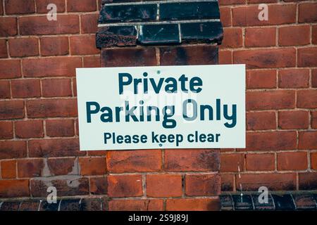 Nur Privatparkplätze. Bitte halten Sie das Schild an einer roten Backsteinmauer frei, Wickford, Esse, Großbritannien. Stockfoto