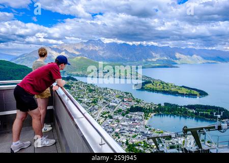 Ein paar Touristen genießen einen Panoramablick auf Queenstown, Lake Wakatipu und die Aussichtsplattform der Skyline Gondel in Neuseeland, Neuseeland Stockfoto