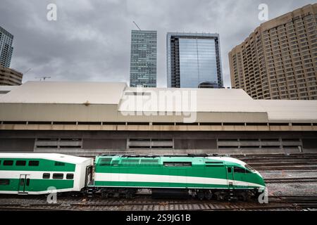 Selektive Unschärfe in Einem grün gestreiften Vorortzug, der in Richtung toronto in ontario, kanada, durch die Skyline der Stadt, die effiziente pu symbolisiert, in Richtung Bahnhof fährt Stockfoto