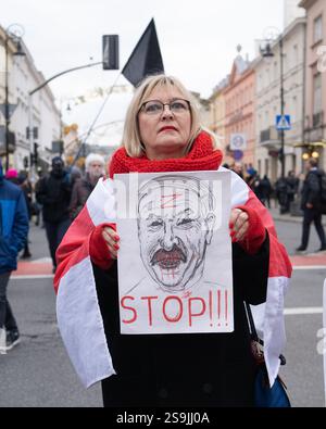 Eine Frau, die in eine historische belarussische Flagge gehüllt ist, hält ein Plakat mit dem Bild von Alexander Lukaschenko, der blutig ist und den Buchstaben Z auf der Stirn trägt, während sie am Marsch der belarussischen Menschen teilnimmt. Viele Weißrussen auf der ganzen Welt kamen zusammen, um gegen die Präsidentschaftswahlen in Belarus zu protestieren. Alexander Lukaschenko, der das Amt seit 1994 innehat, sucht eine siebte Amtszeit. (Foto: Marek Antoni Iwanczuk / SOPA Images/SIPA USA) Stockfoto