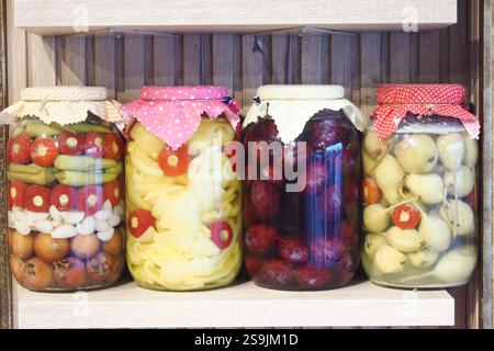 Bunte Auswahl an hausgemachtem eingelegtem Gemüse und Obst auf einem Regal Stockfoto
