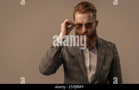Tuxedo bärtiger Mann in eleganter formeller Herrenbekleidung mit Anzugsjacke und Schleife isoliert auf Grau, Kopierraum Stockfoto