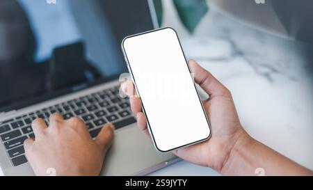 Handy-weißes Bildschirmmockup, menschliche Hand hält Handy mit leerem Bildschirm während der Arbeit im Café, Geschäftsmann mit Smartphone, soziale M Stockfoto