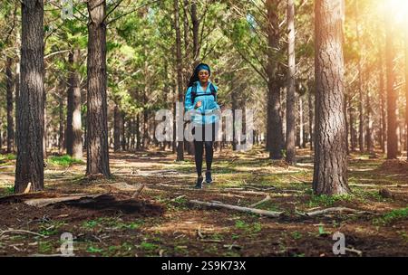 Trail, Laufen und Frau im Wald mit Fitness, Energie oder Wellness beim morgendlichen Workout. Natur, Bäume und Mädchen im Wald für Gesundheit Engagement, Outdoor Stockfoto