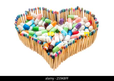 Eine Herzform aus mehrfarbigen Streichhölzern voller Arzneikapseln Stockfoto