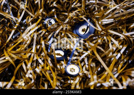 Magnetband mit Bandrollen aufgerollt, magnetische Tonkassetten, die Nostalgie und die Fragilität analoger Medien wecken Stockfoto