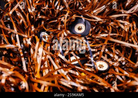Magnetband mit Bandrollen aufgerollt, magnetische Tonkassetten, die Nostalgie und die Fragilität analoger Medien wecken Stockfoto