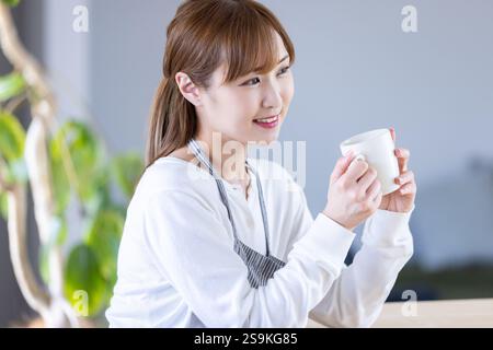 Eine Frau, die sich mit einem Becher unterhält Stockfoto