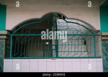 Kunstvoller grüner Metallgrill auf einem Balkon mit Blick auf eine Treppe. Stockfoto