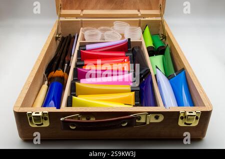 Bunte Kunstgegenstände in einem Holzkoffer. Stockfoto