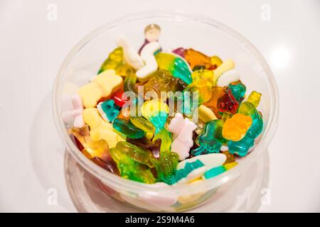 Eine Schüssel gefüllt mit einer Vielzahl von bunten gummiartigen schwedischen Bonbons auf einer weißen Oberfläche. Stockfoto