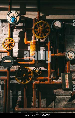 Entlang der Wände des unterirdischen Tunnels sind Metallrohre und Lüftungssysteme installiert. Stockfoto