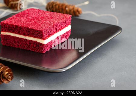 Stück roten Samtkuchen in Teller auf rustikalen Tisch, quadratisch geschnitten, kopieren Raum selektiven Fokus Stockfoto