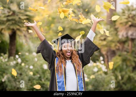 Frau, die Herbstblätter in die Luft wirft Stockfoto