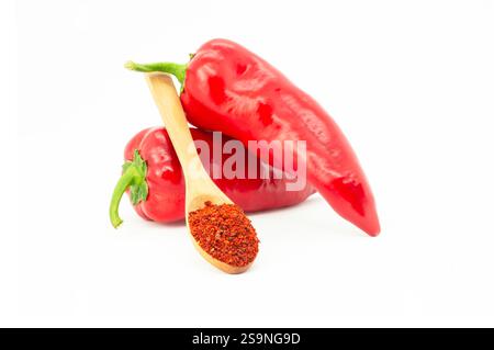 Frische Capia Paprika und Chili Flocken oder Pulver in Holzlöffel isoliert auf weißem Hintergrund, gesunde türkische Gewürz Stockfoto