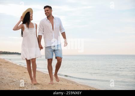 Schönes Paar, das am Strand spaziert. Platz für Text Stockfoto