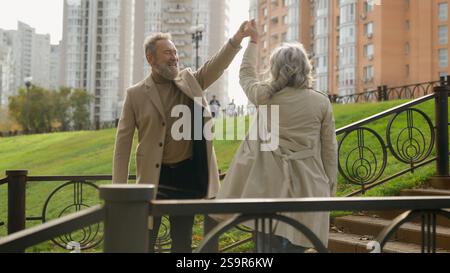 Verheiratetes Paar verliebt Kaukasische Familie älterer Mann reife Frau tanzen zusammen in der Stadt draußen glückliche fröhliche pensionierte Tänzer Ehemann Frau männlich weiblich Stockfoto