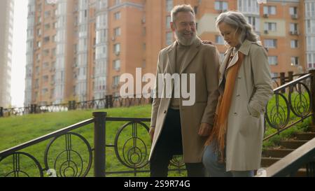 Verheiratetes altes Ehepaar verliebt lächelnde Frau Mann glückliche sorglose kaukasische Familie, die die Treppen in der Stadt hinuntergeht, reife männliche Frau, die zusammen schlendert Stockfoto