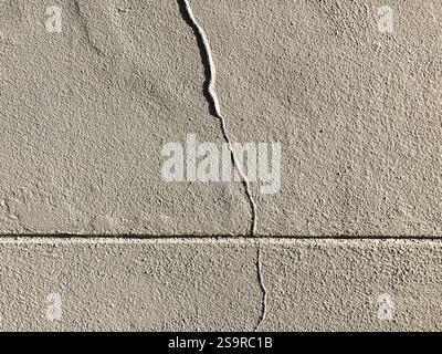 Detaillierte Textur einer gerissenen Betonwand, die die Feinheiten der Oberfläche und ihre Mängel zeigt. Stockfoto