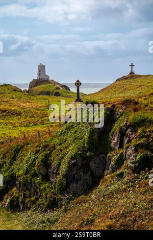 Hügelige Landschaft mit Kreuzen und Leuchtturm auf Ynys Llanddwyn, einer kleinen Insel vor der Küste von Anglesey in Nordwales, Großbritannien. Stockfoto