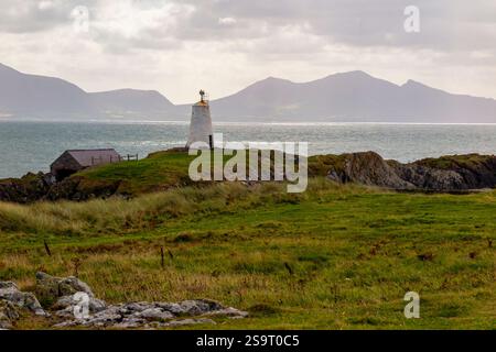 Die Berge von Snowdonia im Hintergrund und das Meer der Menai-Straße von Ynys Llanddwyn vor der Küste von Anglesey in Nordwales Großbritannien Stockfoto