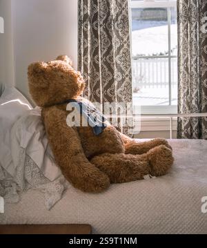 Ein Teddybär, der auf einem Bett schläft. Stockfoto