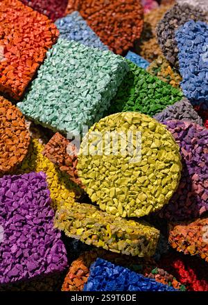 Mehrfarbige Bodenbeläge aus lackierten Gummibröseln, Produkte aus dem Recycling alter Autoreifen. Nahaufnahme, abstrakte geometrische bunte Ba Stockfoto