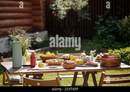Tisch im Freien mit frischem Obst und Blumen Stockfoto