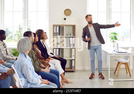 Professioneller Business Coach hält eine Präsentation für ein vielfältiges Publikum im Büro Stockfoto