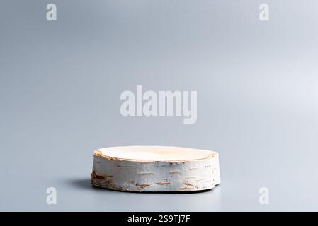 Leeres Holz geschnittenes Poduim für die Produktanzeige. Holzbirkensockel auf neutralgrauem Hintergrund, Vorlage. Stockfoto