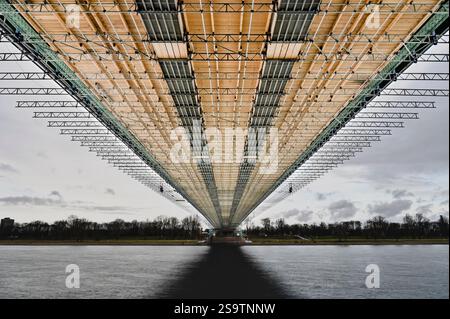 Ein riesiges Bauwerk erstreckt sich über das Wasser und zeigt komplizierte Balken und Stützen. Die Szene fängt die beeindruckende Architektur von unten ein, Highlight Stockfoto
